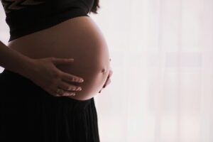 pexels photo 57529 57529 A close-up of a pregnant woman touching her bare belly, expressing warmth and care.